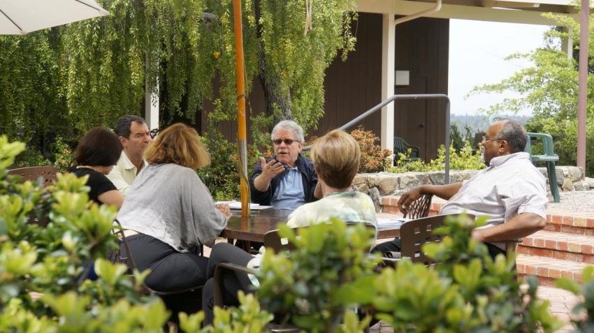 People in discussion around an outdoor table
