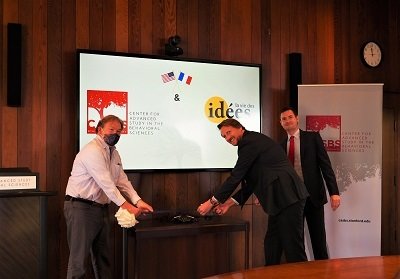 Woody Powell, Frédéric Jung, and Jules Naudet cutting a ceremonial ribbon