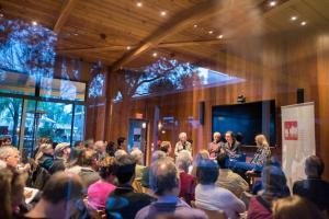 Panel of speakers facing a crowd