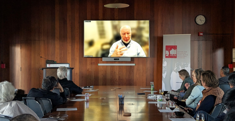 Robert Putnam appearing live on the big screen in CASBS's main meeting room, speaking to a filled room