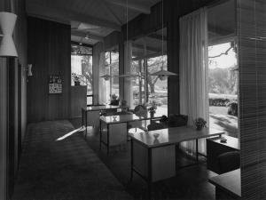 The CASBS building with a row of desks by the glass-paned walls