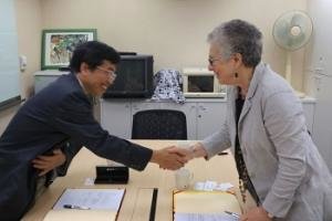 STPI's Yuh-Jzer Joung and CASBS's Margaret Levi shake hands across the table