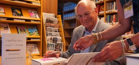 Daniel Kahneman signs copies of "Thinking, Fast and Slow" in CASBS's library reading room in 2013. [CASBS files]